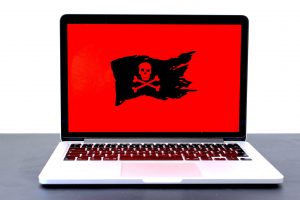 Image of a black and red skull on the screen of an open laptop